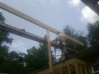 Carpenter setting a ridge beam over a new addition frame — Ice Dam Removal by Roofing Brothers in Iron Ridge