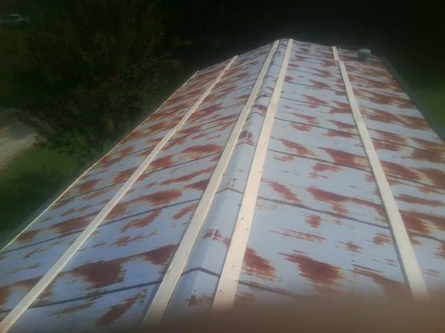 Rusted metal roof panels with new wood purlins before replacement — Storm Damage Roof Repair in Iron Ridge by Roofing Brothers